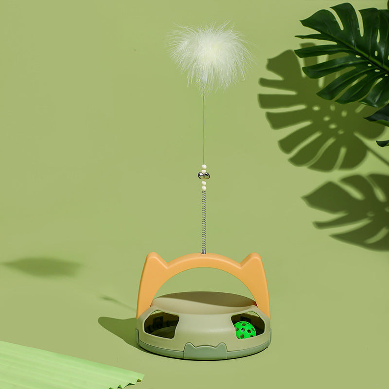 Cat toy with a feather attachment presented on a green surface